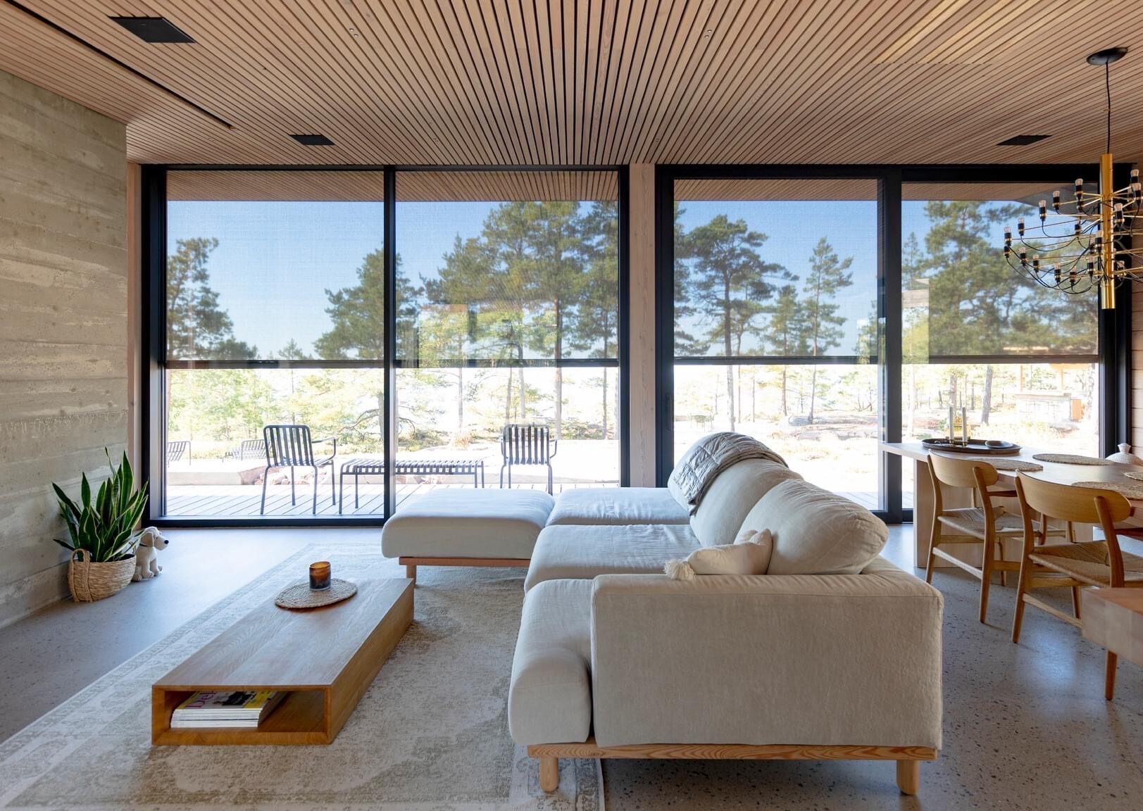 Salon moderne avec de grandes baies vitrées, protégées du soleil par des stores FixScreen RENSON