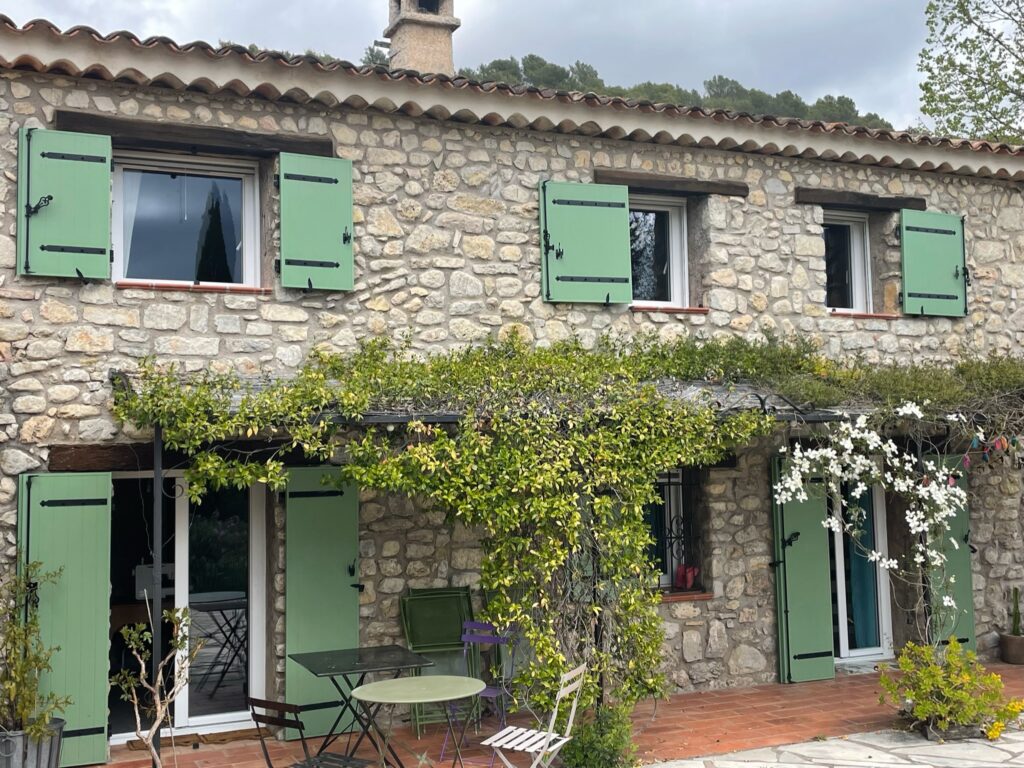 façade en pierre avec volets verts