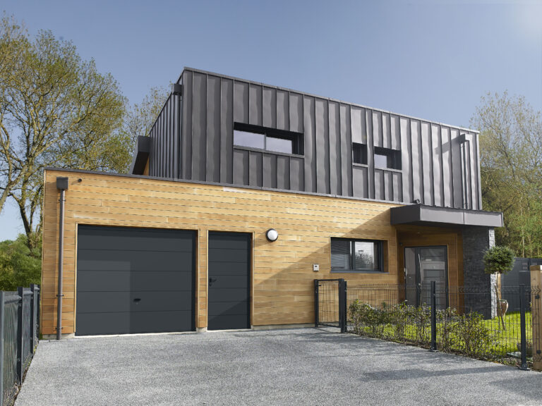 Porte de garage grise anthracite sur une façade en bois